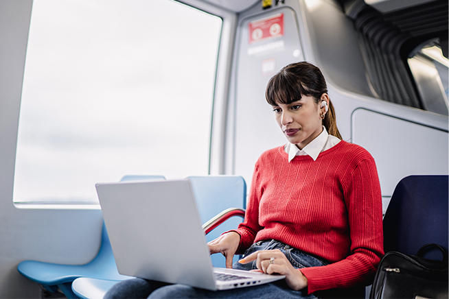 Femme utilisant un ordinateur portable dans un bus.