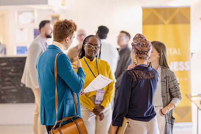 People standing together talking indoors.
