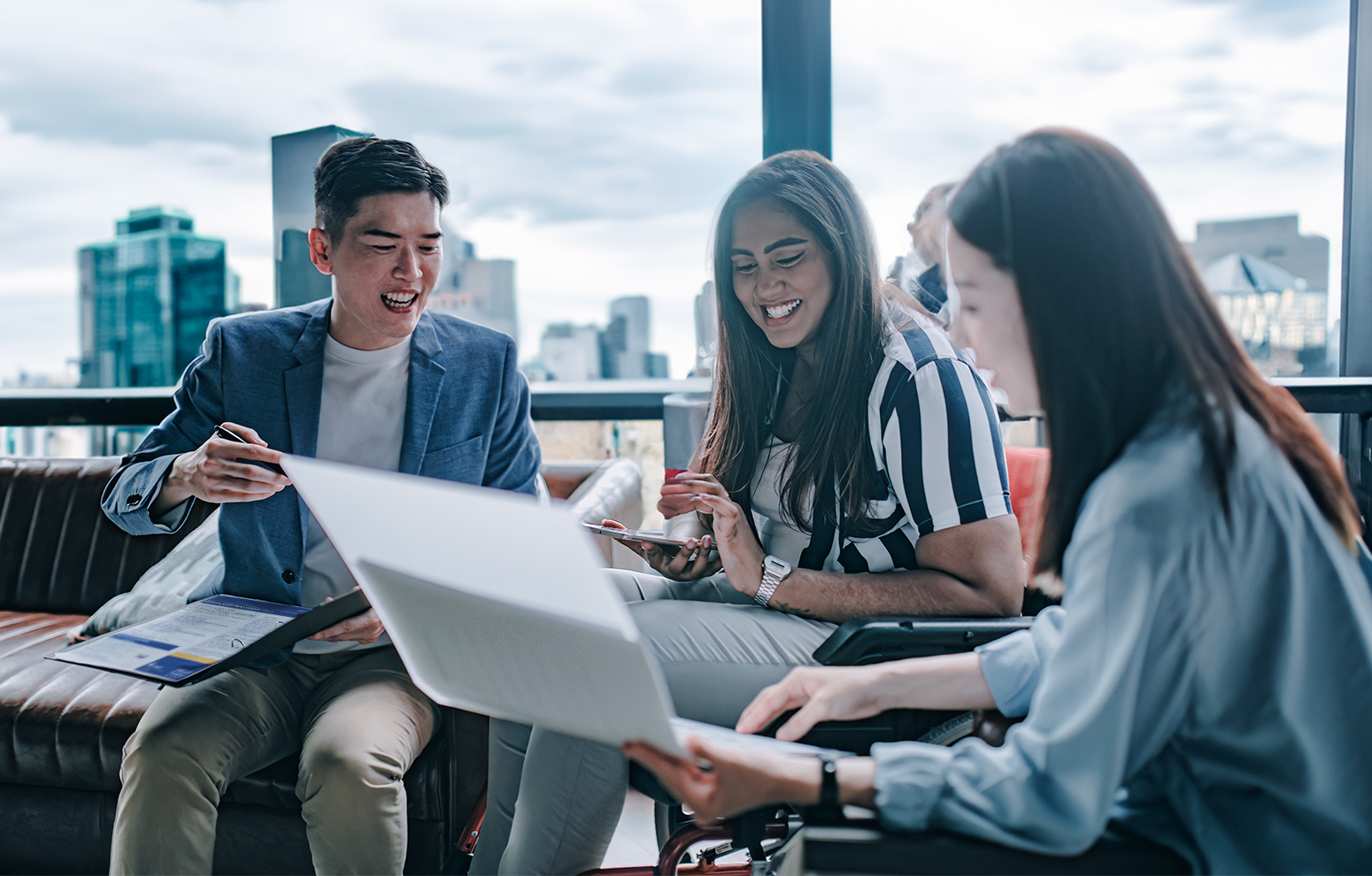 Three colleagues study document against large pane window