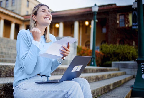 Woman sits on steps after getting good news