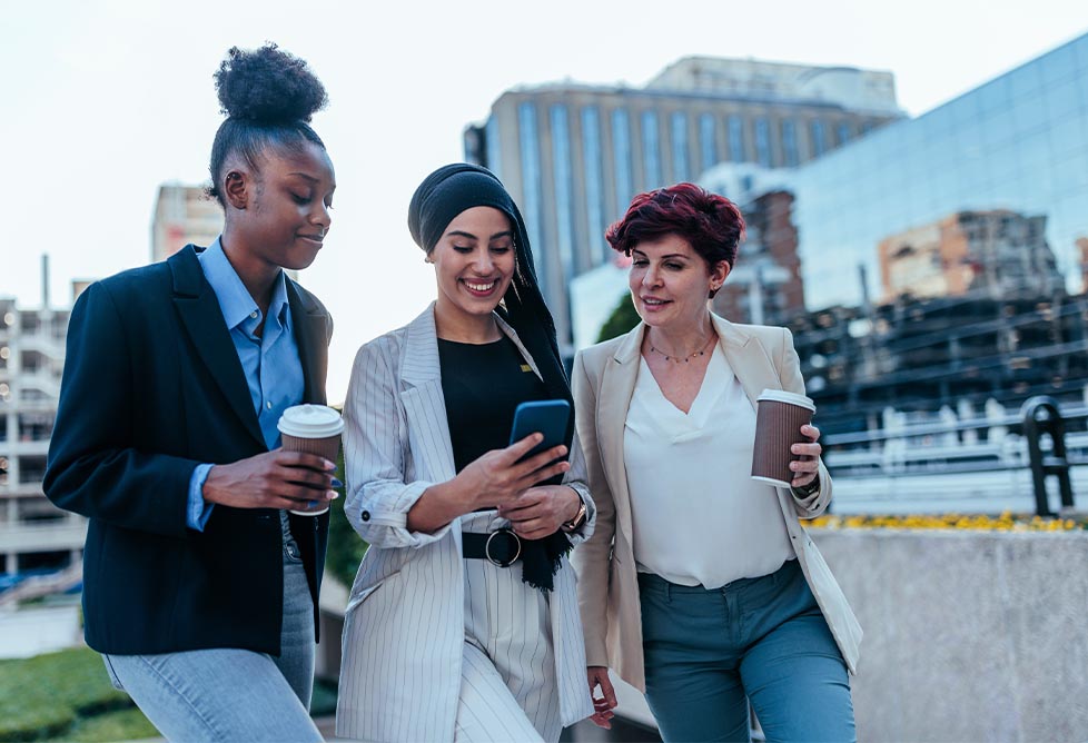 Group of people looking at a cellphone.