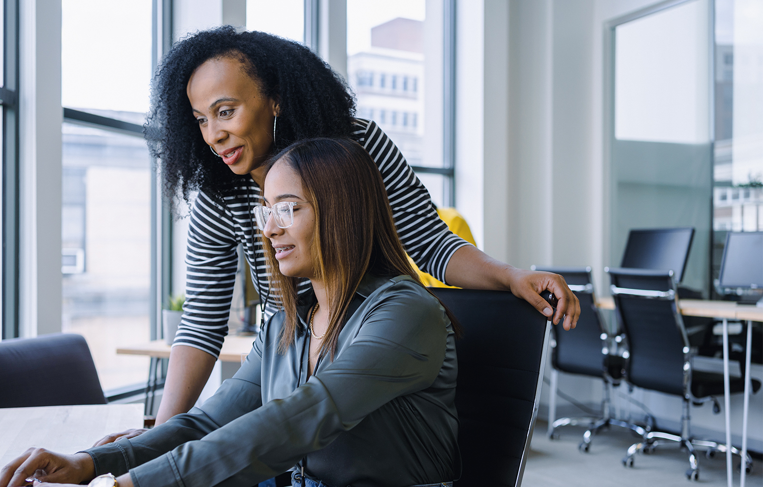 Two women looking at the computer together.