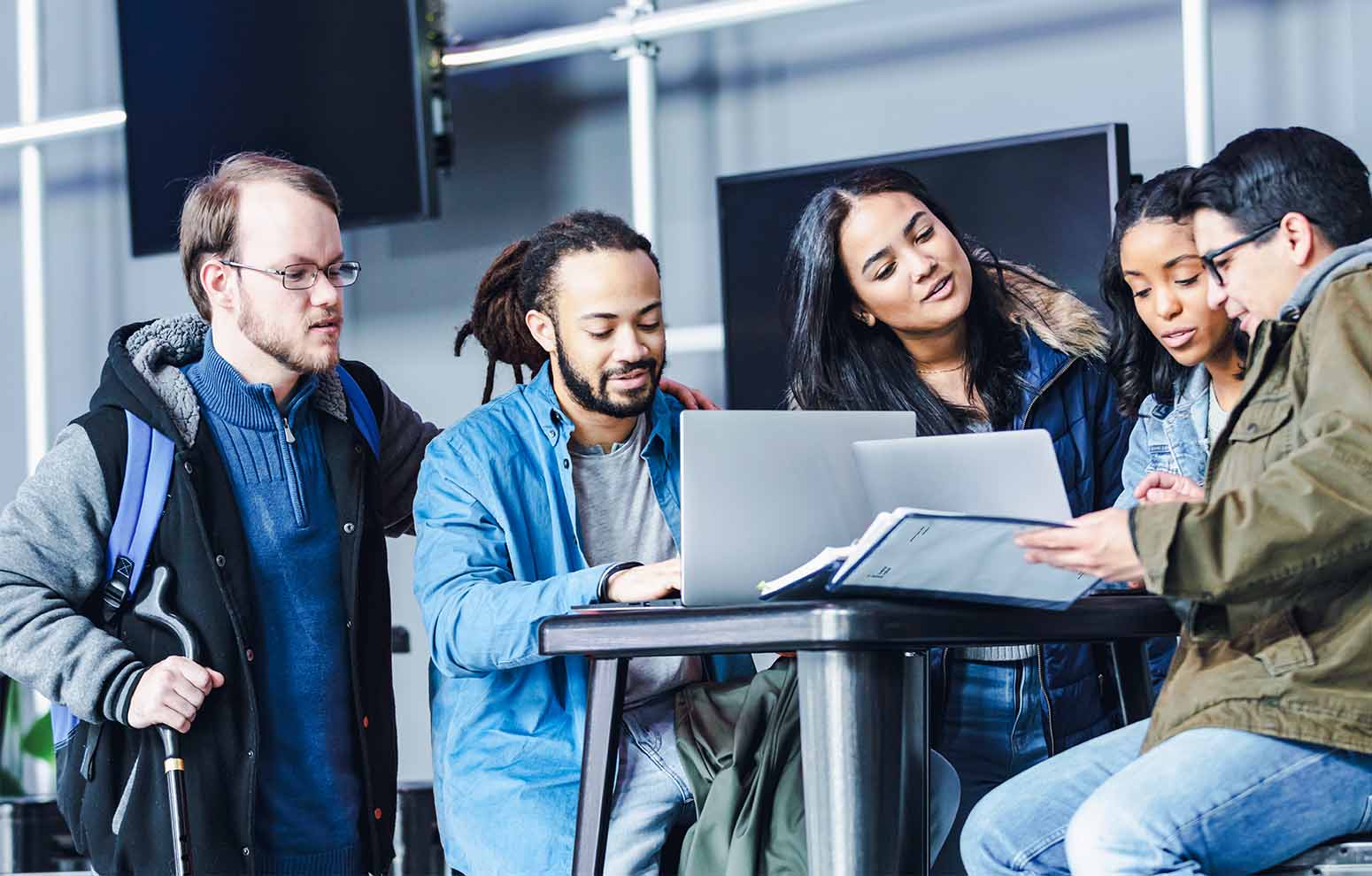 Des personnes utilisant un ordinateur et révisant des documents.