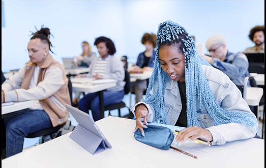 Girl with blue braids at classroom desk