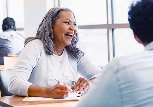Femme souriante assise à un bureau