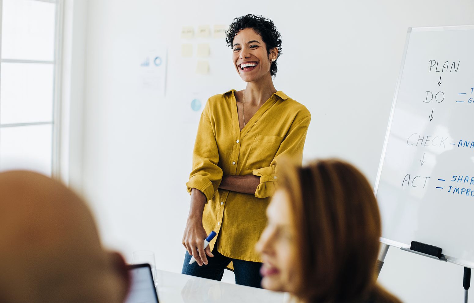 Instructor stands in front of whiteboard facing adult class