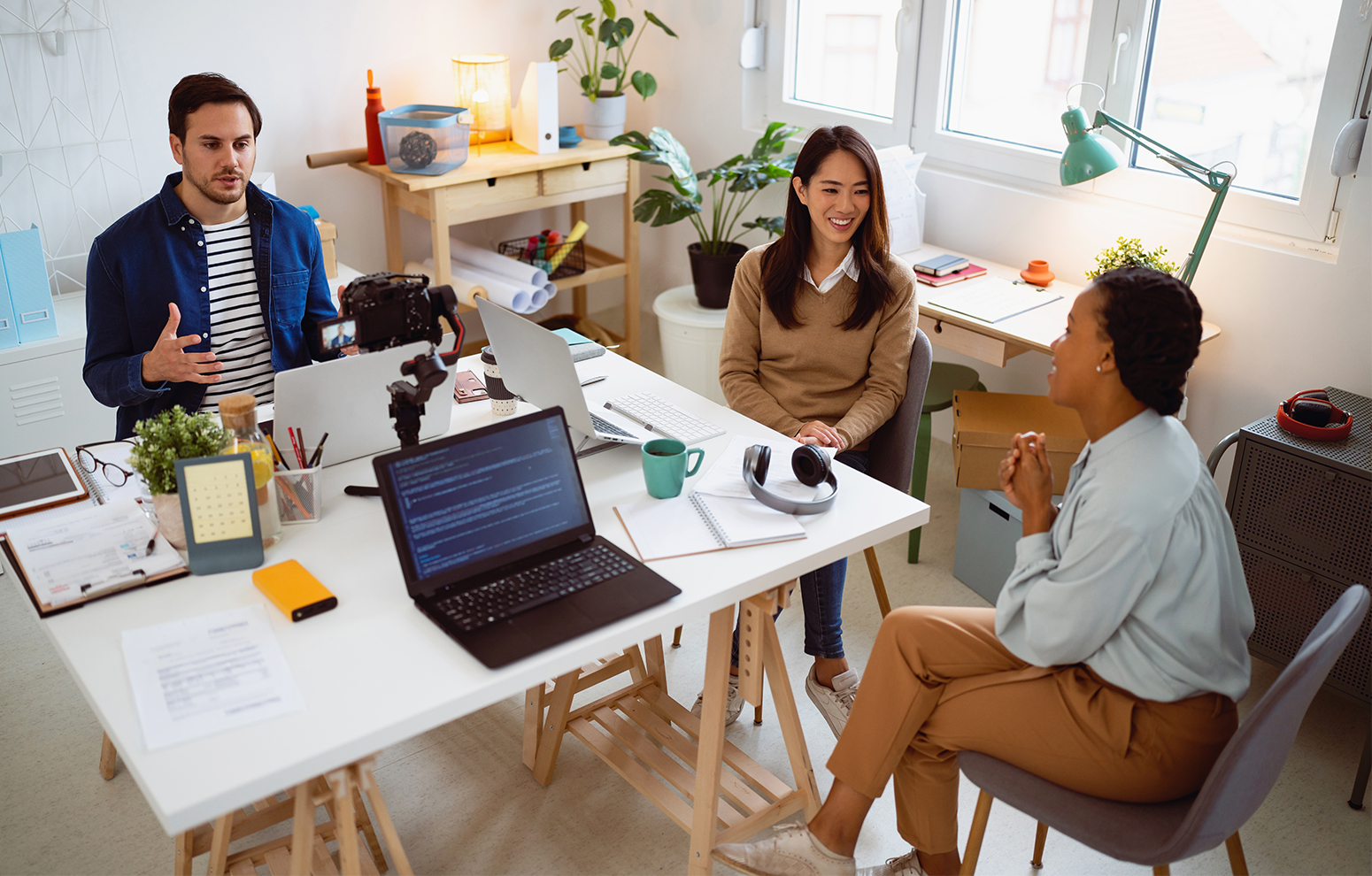 Groupe de personnes assises autour d’un bureau et discutant.