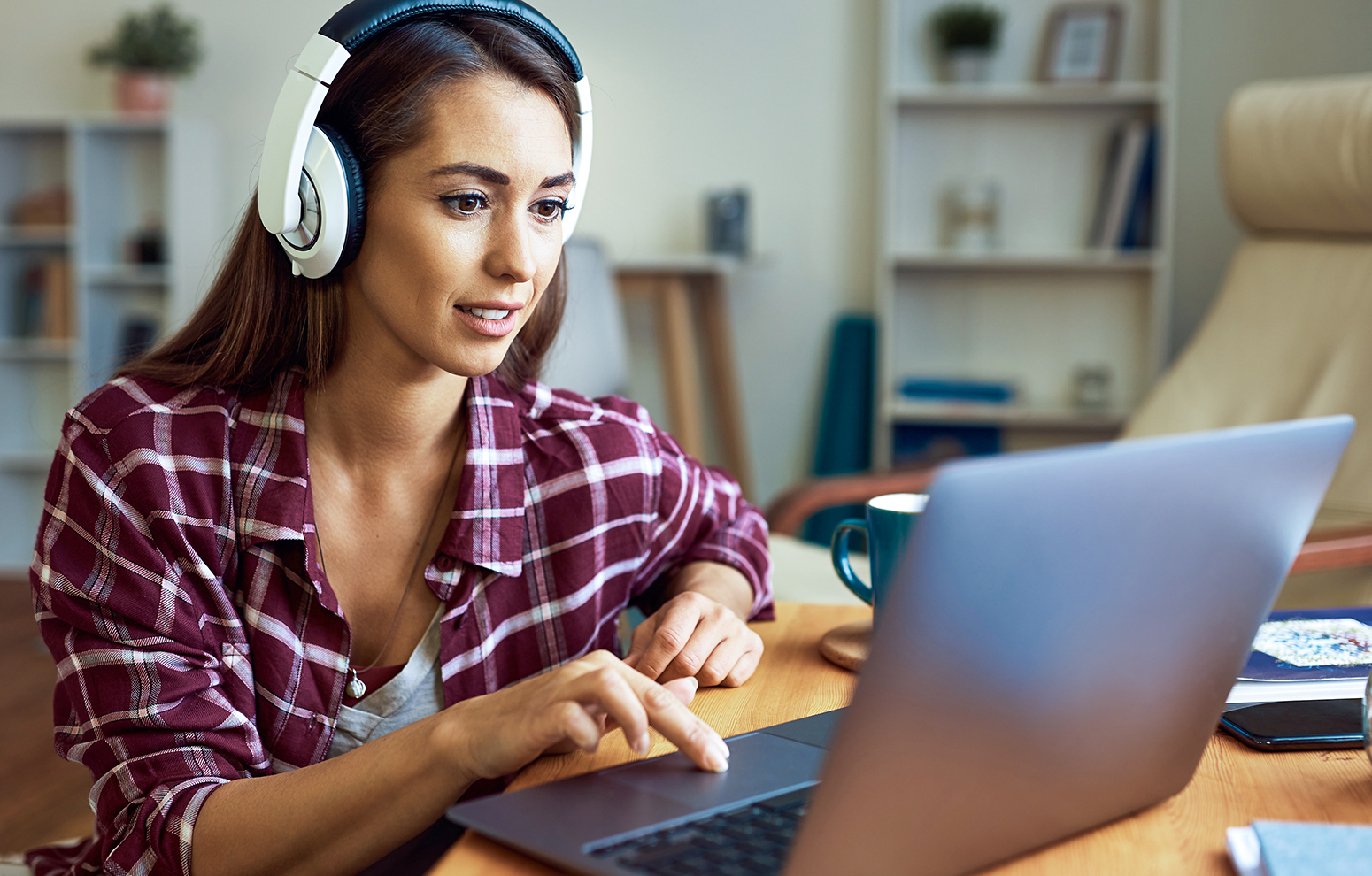 Woman wearing headphones using computer.