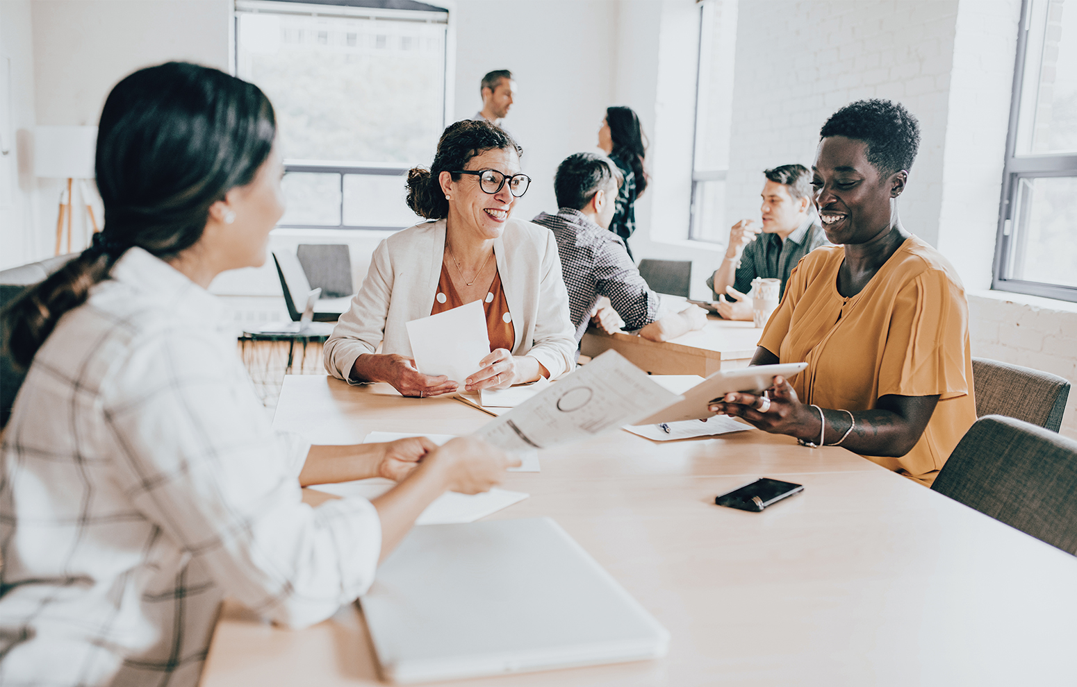 Group of people at a desk talking.
