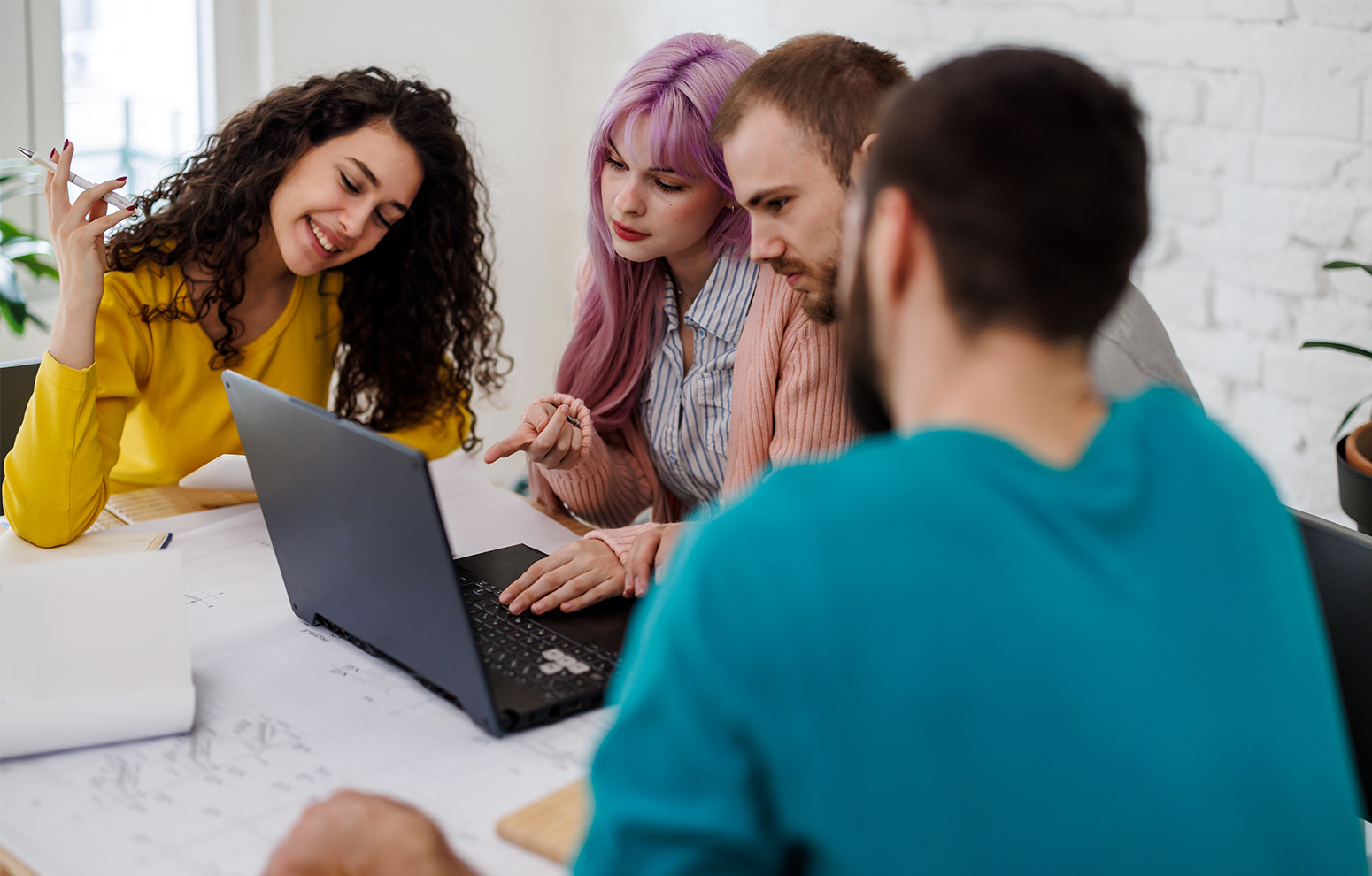 Group of students gathers around a laptop