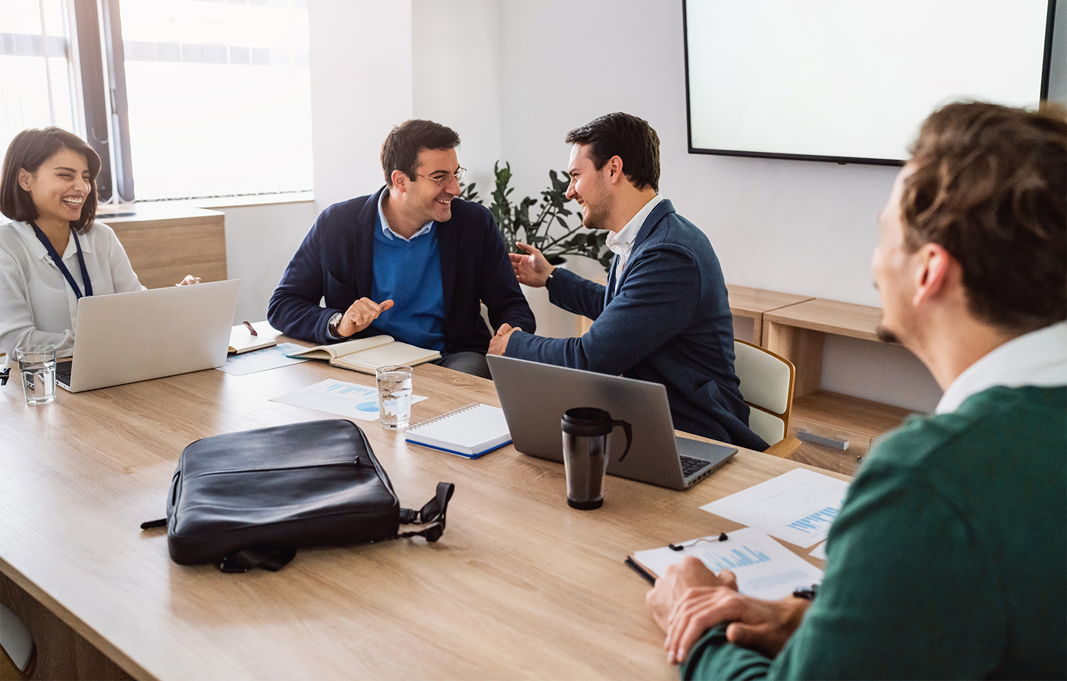 Des gens se réunissent dans un bureau avec des ordinateurs.