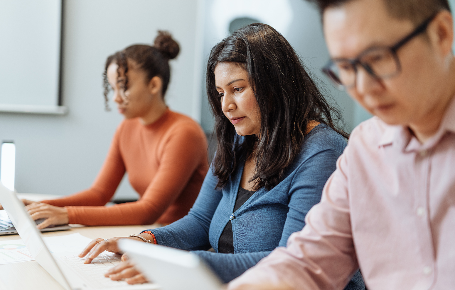 People at a desk using computers.