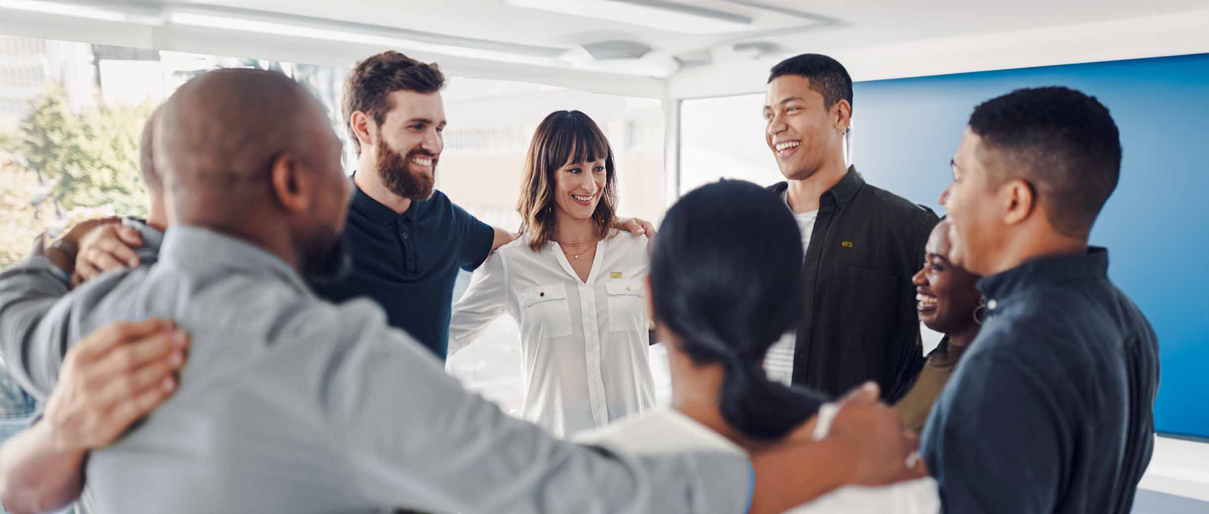 Professionals stand in team building circle