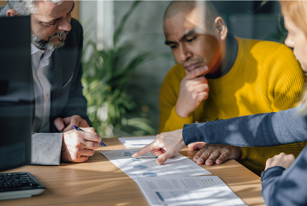Group of people review a document.