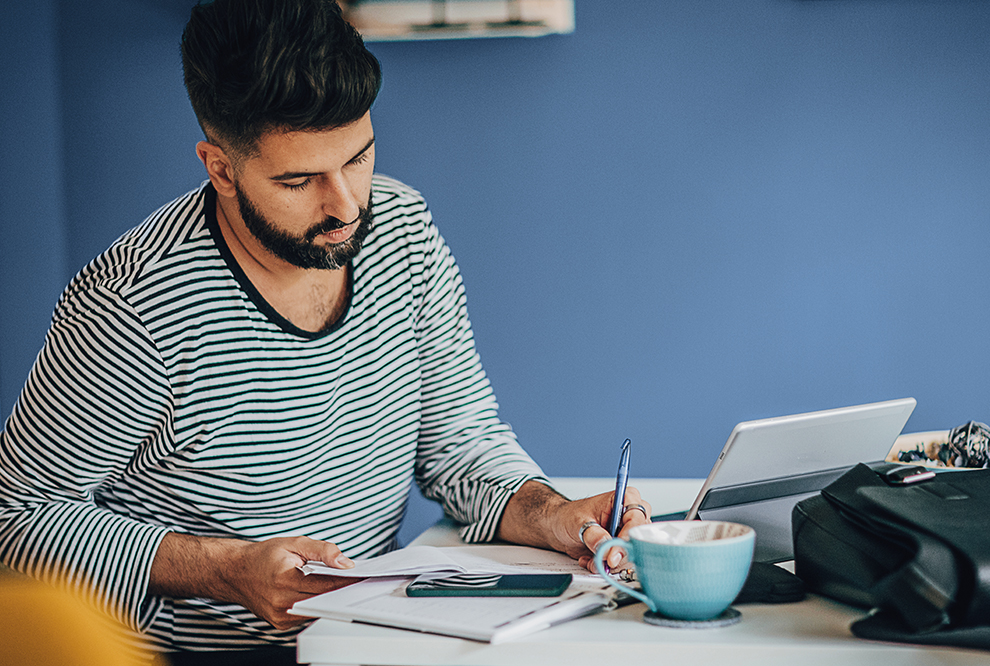 Man works on documents at a desk. 